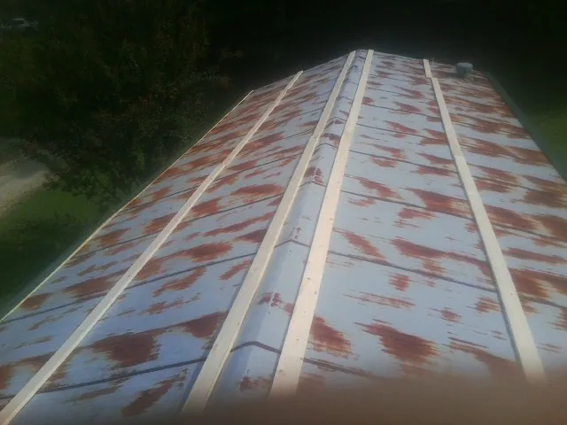 Rusted metal roof panels with new wood purlins before replacement — Storm Damage Roof Repair in Andover by Roofing Brothers